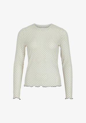 Top de manga larga en blanco con lunares negros. Presenta un escote redondo, dobladillo con borde en forma de ondas y detalle de puño en las mangas. Tejido suave y ligero.