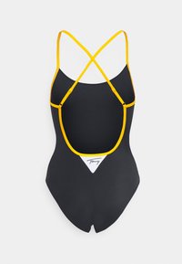 Costume da bagno nero con spalline incrociate gialle e un accento triangolare bianco sul retro con il logo del marchio. Texture liscia e design aderente.
