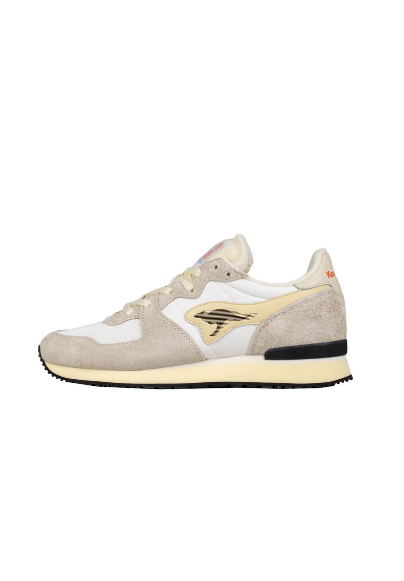 Sneaker beige e bianco realizzato in materiali scamosciati e mesh, con un logo giallo a contrasto e una suola in gomma nera.