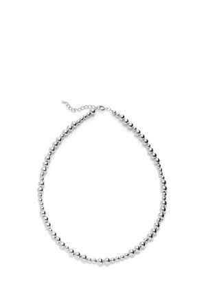 Srebrny naszyjnik z koralikami o różnej wielkości oraz małym przedłużeniem łańcuszka na białym tle.