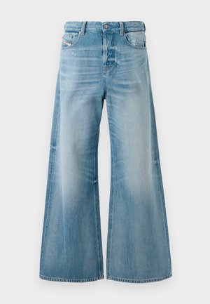 Jeans en denim bleu clair à jambes larges avec un léger délavage et des détails usés aux poches avant, fermetures à bouton et passants de ceinture.