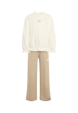 Crèmekleurige trui met lange mouwen en gerimpelde boorden, gecombineerd met beige wijde broek, beide met een klein Adidas-logo.
