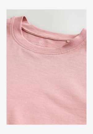 Svjetloružičasta majica regularnog kroja. Okrugli izrez, glatka tekstura i suptilni heather uzorak. Oznaka kaže "NEXT."
