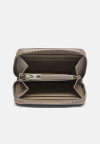 Beżowy portfel zapinany na zamek wokół, wykonany ze skóry i materiału tekstylnego, wyposażony w wiele przegródek, gładką fakturę oraz srebrne okucia.