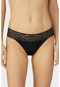 Cotton bikini nera con una fascia in pizzo decorata da motivi ondulati. Il tessuto principale è liscio ed elastico.