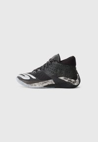 Baskets noires de sport avec tige en mesh texturé, détails réfléchissants et accents gris. Presentent une semelle rembourrée pour le soutien et l'adhérence.