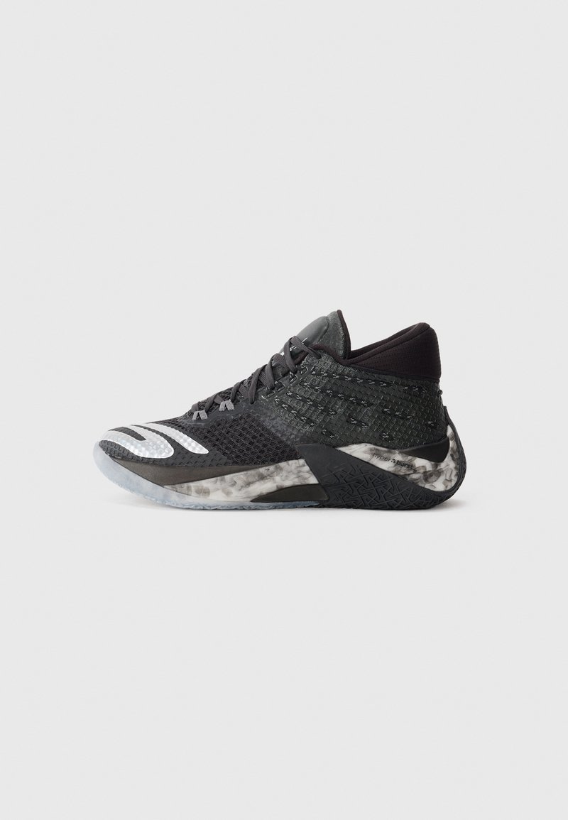 Baskets noires de sport avec tige en mesh texturé, détails réfléchissants et accents gris. Presentent une semelle rembourrée pour le soutien et l'adhérence.