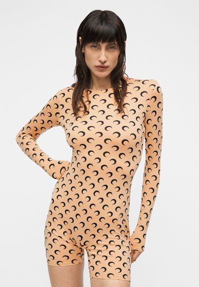 Ολόσωμο κορμάκι σε ροδακινί ύφασμα με μοτίβα μαύρου ημισελήνου, μακριά μανίκια και εφαρμοστή γραμμή. Λείο ύφασμα και ελαστικός σχεδιασμός.