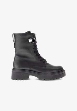 Schwarze Leder-Ankle-Boots mit einer groben Sohle, Schnürdesign und silbernen Hardware-Details. Strukturierte Oberfläche mit Zugschnalle an der Rückseite.