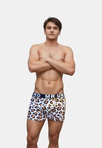 Kalsonger med vit bas, prydda med ett svart och tan leopardmönster, samt en svart midjeresår med texten "MR UK".