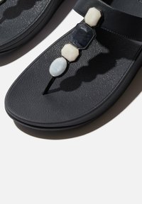 Infradito neri con suola testurizzata, pietre decorative in resina di forme e colori variabili, e design a una sola fascia.