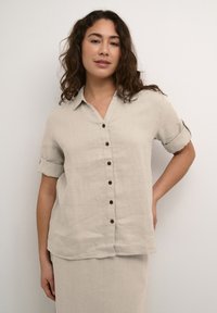 Beige linnen button-up overhemd met korte opgerolde mouwen, een kraag en houten knopen aan de voorkant. Relaxte pasvorm met een licht gebogen zoom.