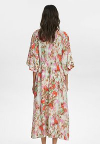 Rochie maxi dintr-un material ușor, cu un model floral multicolor în nuanțe de roz, verde și portocaliu. Croi lejer, cu mâneci tip kimono.