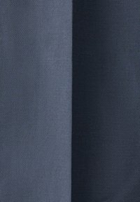 Tofarvet stofprøve, der viser et tekstureret, vævet mønster med en lysere gråblå farve til venstre og en mørkere marineblå farve til højre.