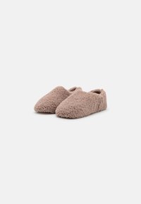 Fuzzy, beige slippers with a rounded shape, soft texture, and open heel design for easy wear. No visible hardware or patterns.