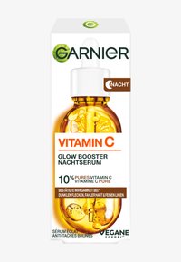 Rund glasflaska med en pipett, fylld med bärnstensfärgad vätska. Lådan har vit och grön text som tydligt visar produktens namn och fördelar.