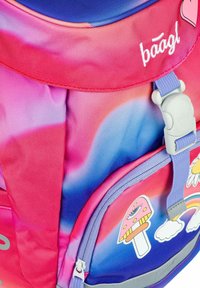 Zaino colorato con una gradazione di tessuto rosa e blu, decorato con adesivi giocosi, un manico superiore e una chiusura in plastica.