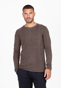 Camicia a maniche lunghe marrone con motivo testurizzato, scollatura a costine e maniche aderenti. Il materiale sembra morbido e leggero.