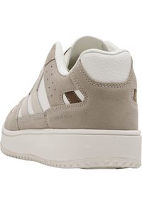 Beige Wildlederschuhe mit weißen Lederakzenten, gepolstertem Kragen, durchbrochenen Details und strukturierten Gummisohlen. "ST POWER PLAY" Branding sichtbar.
