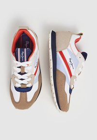 Tenisky s kombinací materiálů: bílý textilní svršek, béžové semišové akcenty, modré a červené pruhy a bílé tkaničky; gumová podrážka.