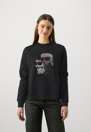 Schwarzer Sweatshirt mit einem mit Strass besetzten Grafikmotiv eines Charakters und einer Katze, die beide Sonnenbrillen tragen. Rundhalsausschnitt, lange Ärmel, lockere Passform.
