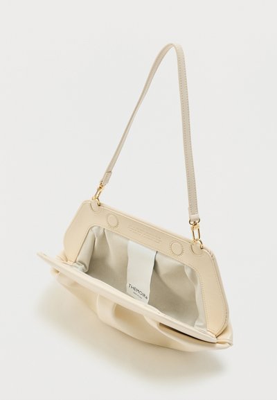Μπεζ δερμάτινη τσάντα ώμου με χρυσά μεταλλικά στοιχεία, ανοιχτό πάνω πλαίσιο και υφασμάτινη εσωτερική ετικέτα που αναγράφει "THEMOIR".
