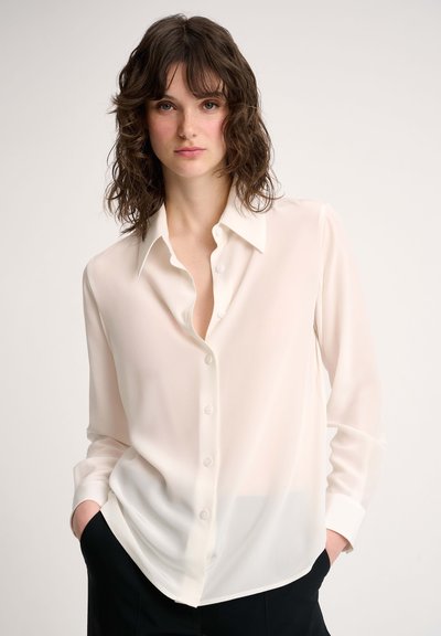 White, long-sleeve blouse in sheer fabric with a button-down front, point collar, and relaxed fit, featuring a slightly longer back hem.