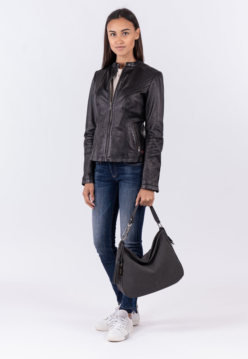 Schwarze Lederjacke mit Stehkragen, strukturierten Schultern, Reißverschluss, kombiniert mit dunklen Jeans und einer lässigen schwarzen Handtasche.