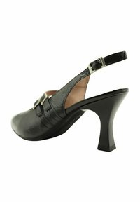 Zapato de tacón alto negro tipo slingback con parte superior de cuero texturizado, correa ajustable y tacón sólido. Presenta un detalle decorativo de hebilla.