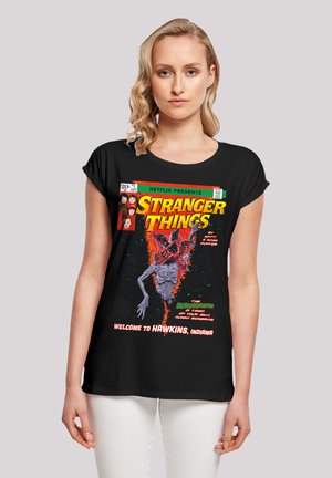 Schwarzes T-Shirt mit einem bunten retrograﬁschen Druck eines Monsters, dem "Stranger Things"-Logo und einem Textdesign. Kurze Ärmel, lockere Passform.