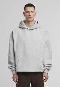 Grauer Kapuzenpullover aus weichem Material mit einer Fronttasche und gerippten Bündchen. Bietet eine lässige Passform und minimale Nähte entlang der Nähte.