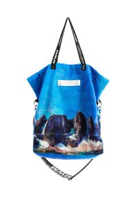 Bolsa azul con estampado de montaña, tela texturizada, asas cortas y una correa desmontable. Presenta un detalle plateado y una etiqueta impresa.