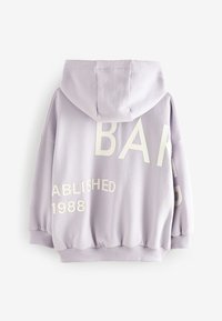 Lilla oversized hoodie med en front kanguru-lomme. Har hvid tekst "BAND" og "ESTABLISHED 1988" trykt på ryggen i forskellige størrelser.