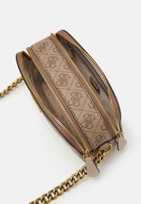 Compact beige en bruine gestreepte crossbody tas met twee open gouden ritscompartimenten en een chunky gouden kettingband.