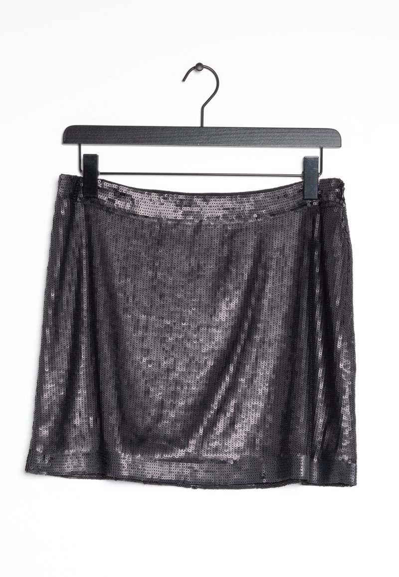 Jupe noire à sequins suspendue sur un cintre noir sur un fond blanc.
