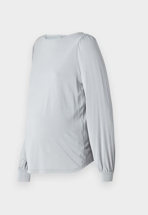 Light gray, long-sleeve top with a rounded neckline, puffed sleeves, and a loose fit, designed for comfort during pregnancy.