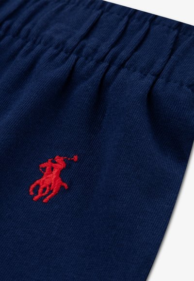 Σορτς από βαμβάκι σε ναυτικό μπλε με ελαστική μέση. Διακοσμημένα με κόκκινο κεντημένο λογότυπο παίκτη πόλο και αλόγου. Ομαλή υφή.