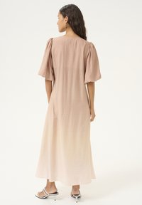 Maxime dress in a soft beige color, featuring a relaxed fit with puffed sleeves, textured fabric, and a gradual ombre effect towards the hem.