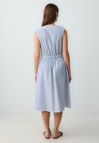 Ärmelloses blau-weiß gestreiftes Kleid mit elastischem Bund, knielanger Länge und glattem Stoff. Einfaches Design und lockere Passform.