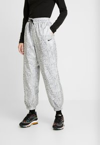 Nike sweatpants med grå och svart ormskinneprint, elastisk midja med dragsko, sidofickor och smalnande mudd.