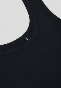 Czarna koszulka na ramiączkach z okrągłym dekoltem i przeszytymi brzegami. Miękka tkanina z małą metką marki w okolicy szyi.