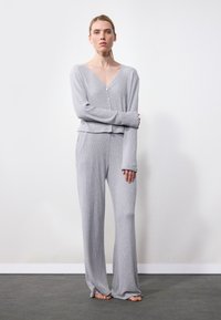 Set de îmbrăcăminte de lounge din tricot gri cu dungi, care include un cardigan scurt cu decolteu în V și detalii cu butoane, mâneci lungi, asortat cu pantaloni largi.