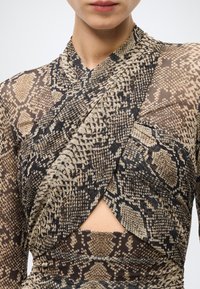 Vestito a maniche lunghe con stampa snake in tonalità terra di marrone, sabbia e nero. Design avvolgente con dettaglio cut-out in vita.