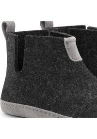 Zwarte vilten enkellaarsjes met grijze suède accenten en handvatten. Beschikt over een gestructureerd oppervlak en een gestikte naad langs de zool voor duurzaamheid.