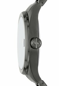 Svart analog klocka med en slät bezel, rund klockkropp och texturerad krona med "A"- och "X"-markeringar. Klar glasfront.