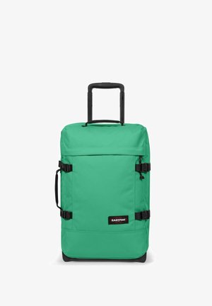 Valigia di tessuto verde con manico telescopico, dettagli neri, fibbie laterali e una patch con il logo sulla parte anteriore. Design liscio e strutturato.