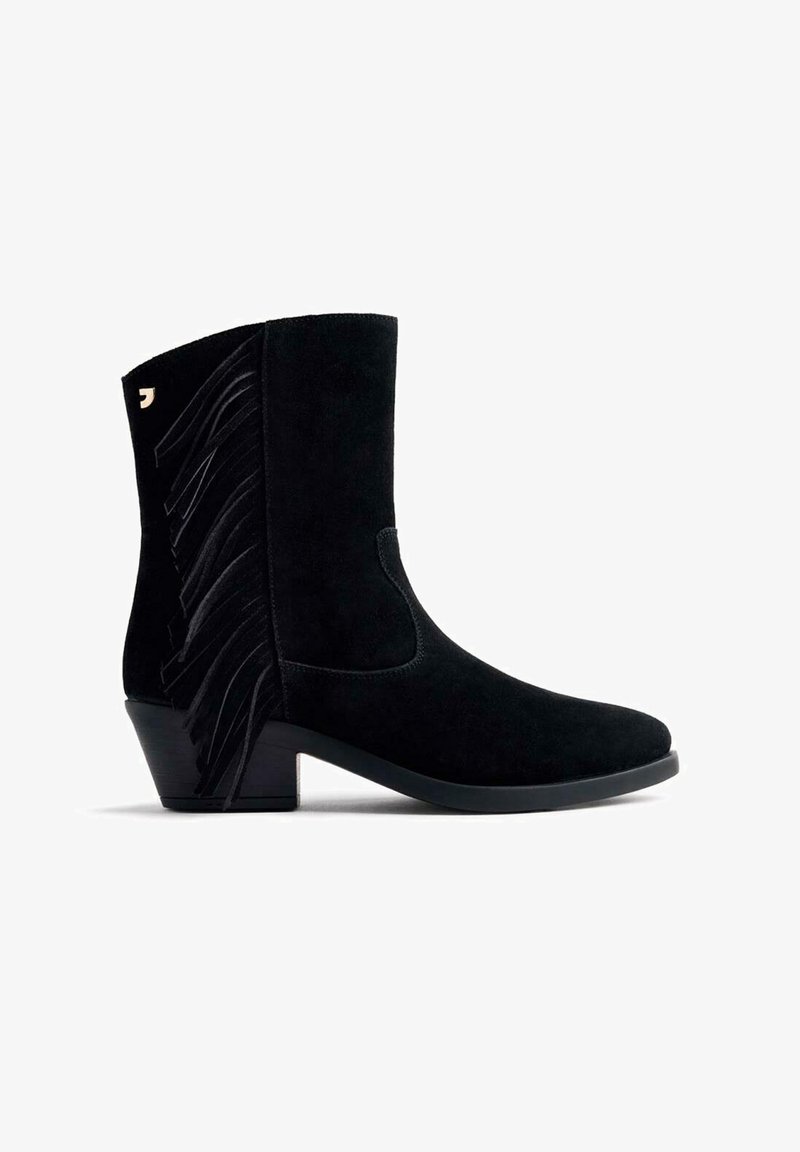 Botín de ante negro hasta el tobillo con punta redonda y tacón corto. Presenta un destacado detalle de flecos negros en el lado exterior.
