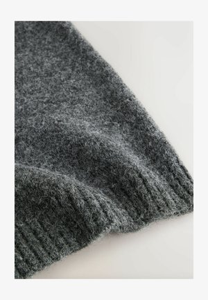 Harmaa neulepuserokangas, jossa on pehmeä rakenne ja ribattuja helmoja, esittää eri harmaan sävyjä hienoilla, karheilla kuiduilla.