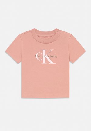Myk rosa baby-t-skjorte med korte ermer og Calvin Klein-logo i hvitt og grått, med rund hals og trykknapper på den ene skulderen.