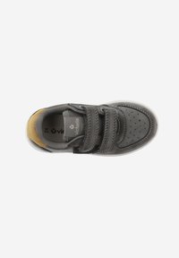 Zapatilla gris de ante y sintética con dos correas de Velcro, área del dedo del pie perforada y suela de goma gris clara. Acentuada con una pestaña en el talón de color marrón claro.
